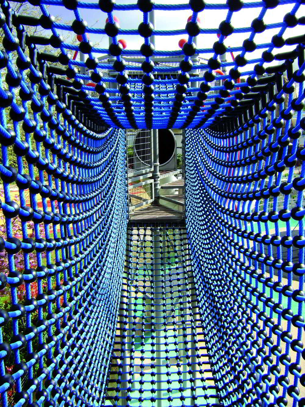 Parque de aventuras con cuerdas y redes Huck Spain instalado en entorno exterior con postes de acero protegido
